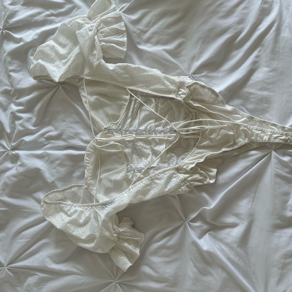 Bodysuit with floral detail and open back.